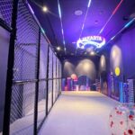 Indoor bumper ball arena with neon Jakarta skyline mural