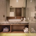 Ashley Hotel Group bathroom with a round backlit mirror