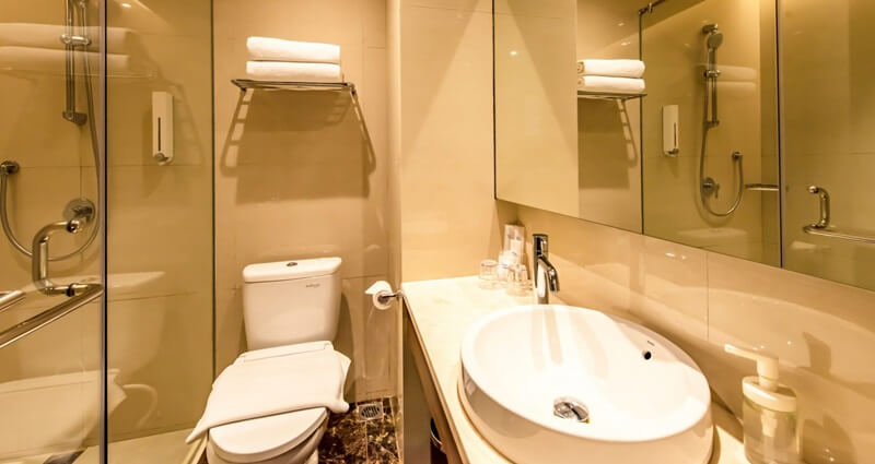 Modern hotel bathroom with a backlit mirror and vanity