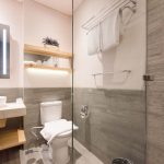 Modern hotel bathroom with a backlit mirror and vessel sink