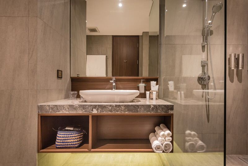 Ashley Hotel Group bathroom with a round backlit mirror