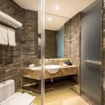 Ashley Hotel Group bathroom with a round backlit mirror