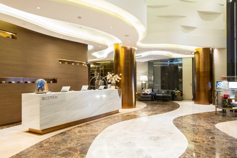 A modern hotel check-in counter with a wooden desk
