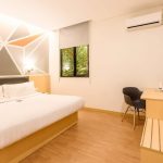 A modern Deluxe Queen hotel room with a large bed