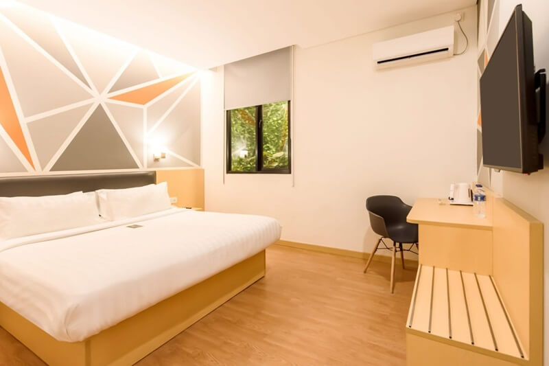 A modern Deluxe Queen hotel room with a large bed
