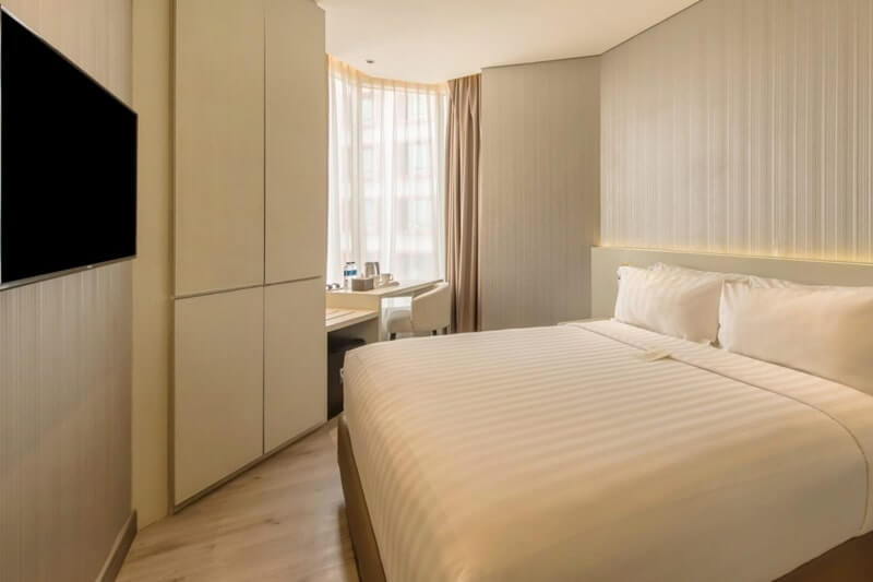 A deluxe double hotel room with a large white bed