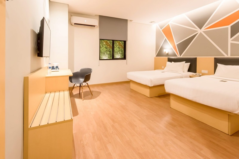A deluxe twin hotel room with two beds