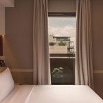 A modern Deluxe Double hotel room with a neatly made bed