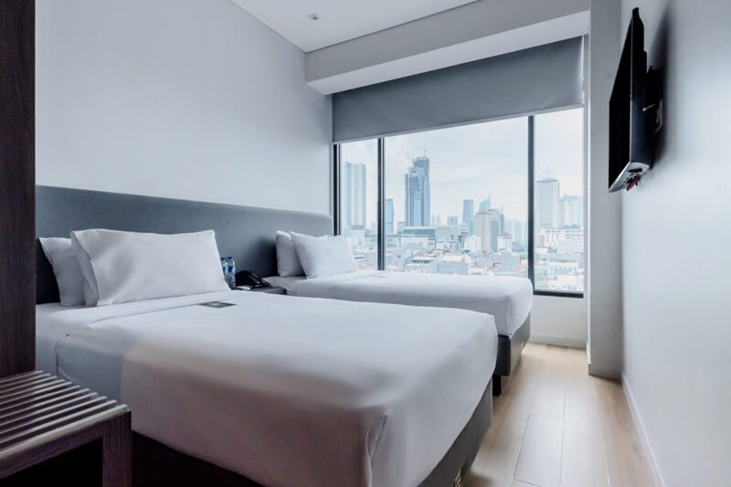 Modern Deluxe Twin room with two beds and a side table