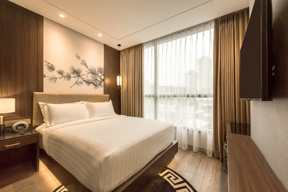Modern hotel double room with a large bed and city view