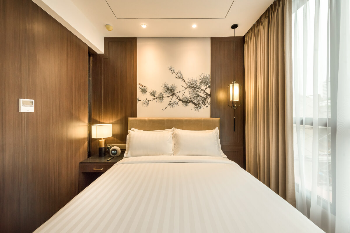 A bright, modern hotel double room with a white bed