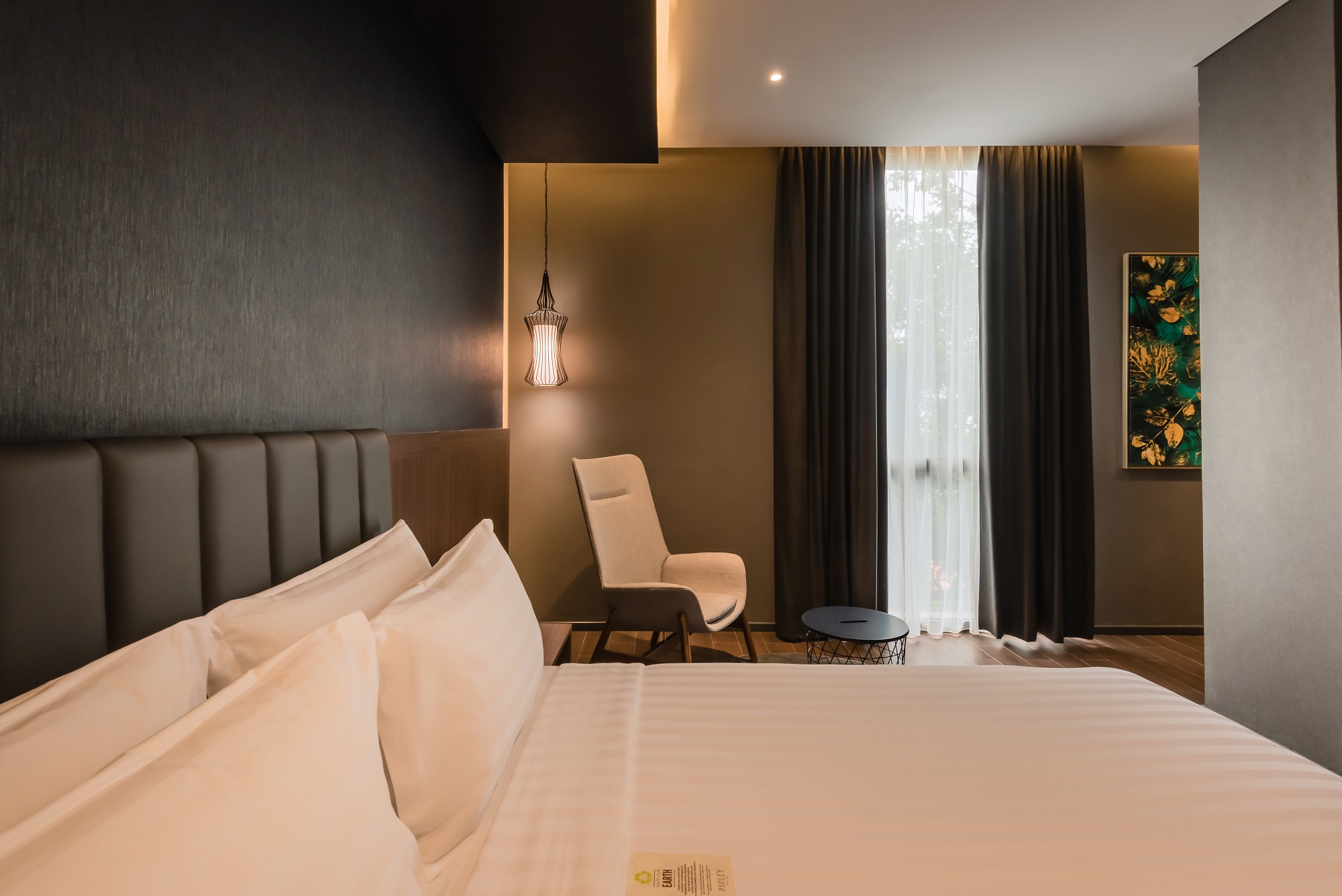 Ashley Hotel room interior with a bed and desk