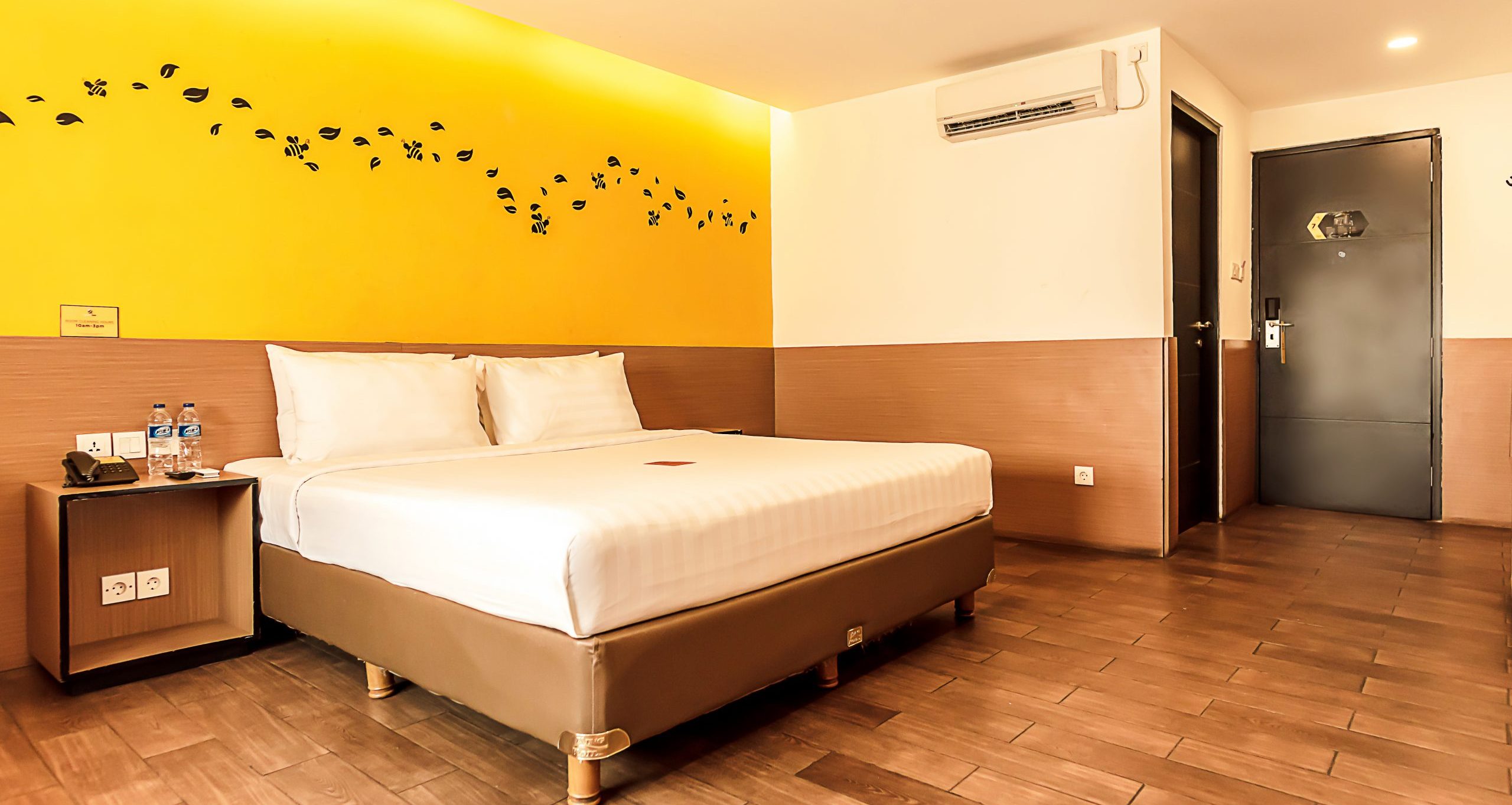 Bright Superior King hotel room with a yellow accent pillow