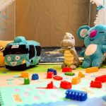 Colorful family room toys on a small white table and chairs