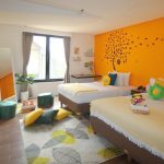 A bright yellow girls' room with two single beds