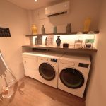 Clean hotel laundry room with stacked washers and dryers