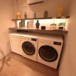 Hotel laundry room with stacked washers and dryers