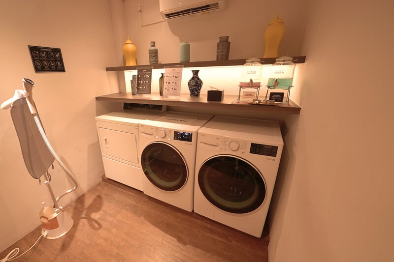 Hotel laundry room with stacked washers and dryers