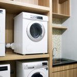 Hotel laundry room with stacked washers and dryers