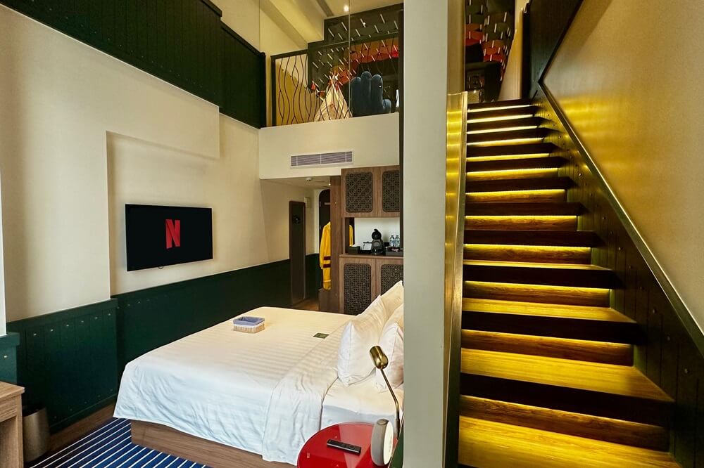Modern hotel loft room with a staircase to the bedroom