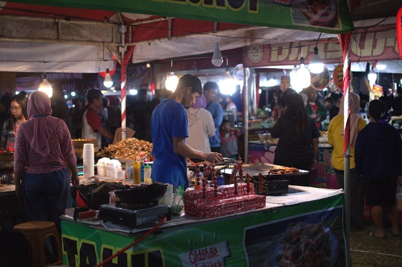 A bustling city neighborhood street scene at night