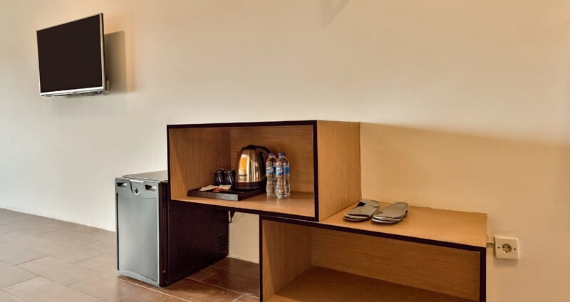 A modern hotel room corner with a bed and side table
