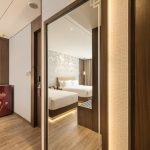 Modern hotel room corner with a white armchair by a window