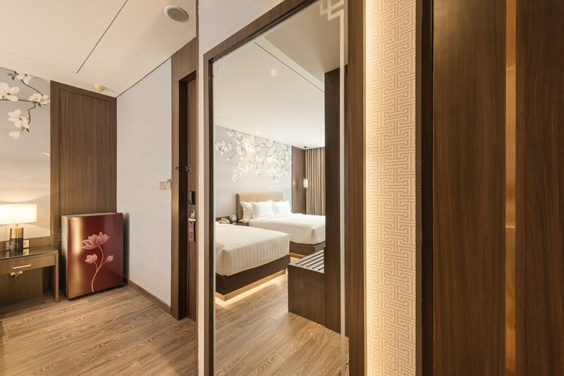 Modern hotel room corner with a white armchair by a window