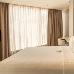 Modern hotel room with a bed and side table