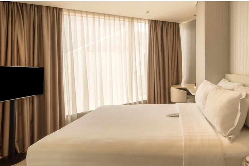 Modern hotel room with a bed and side table