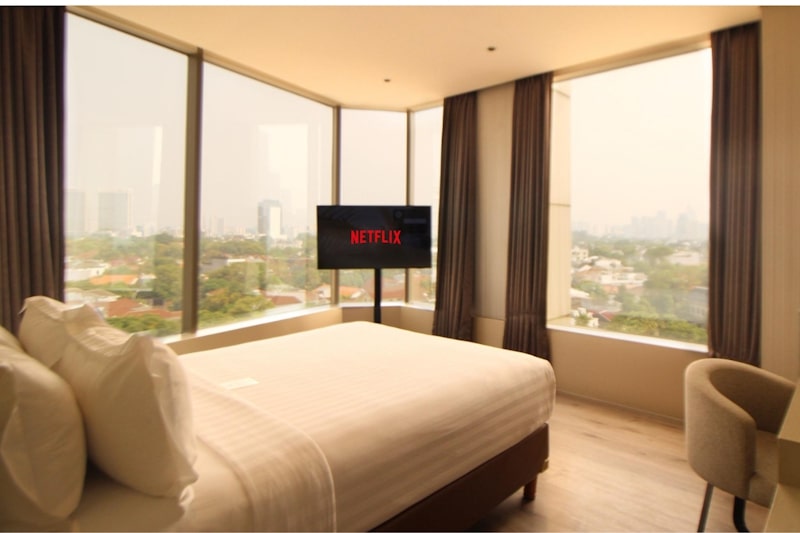 Hotel room4 with a neatly made bed and large window