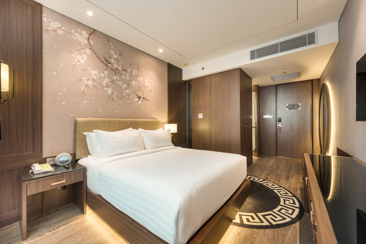 A modern superior hotel room with a large bed and desk