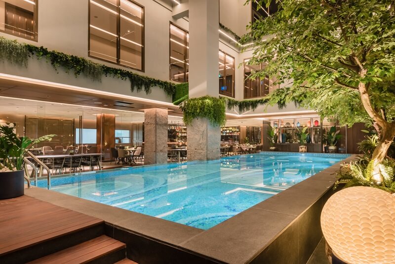 A modern hotel swimming pool with lounge chairs