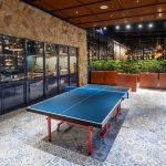 A table tennis table with paddles in a hotel game room