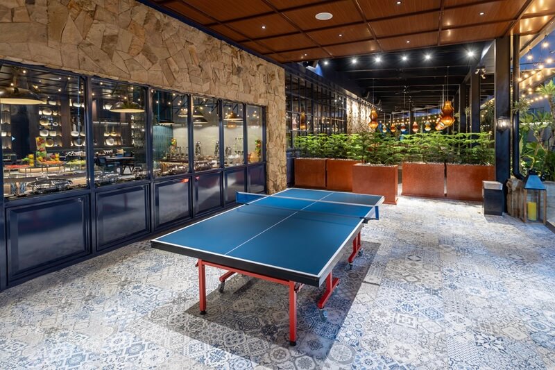 A table tennis table with paddles in a hotel game room