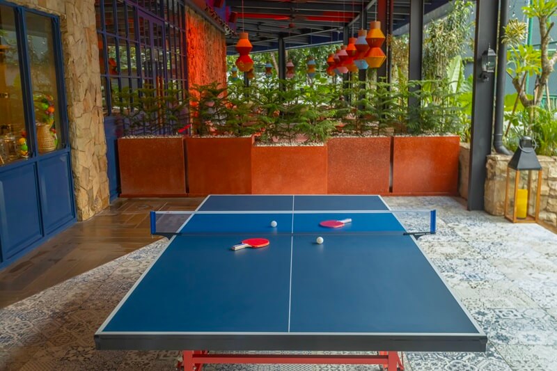 A table tennis table with two paddles and a ball