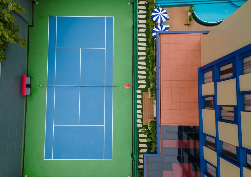 An empty outdoor tennis court with a net