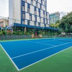 An outdoor tennis court with a green surface