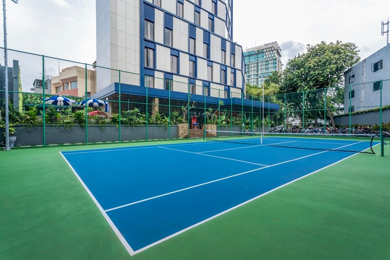 An outdoor tennis court with a green surface