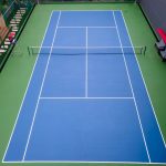 A green outdoor tennis court with a net