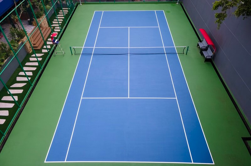 A green outdoor tennis court with a net