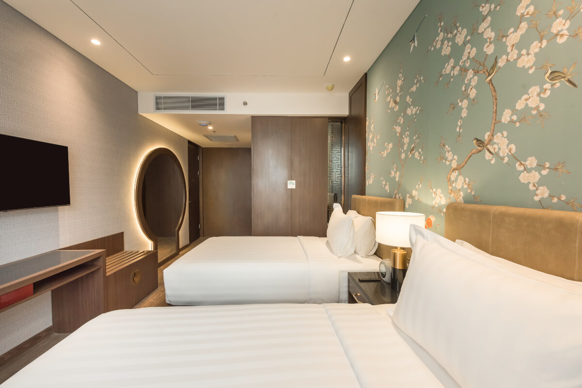 Two twin beds in a modern, well-lit hotel room