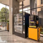 A black vending machine filled with snacks and drinks