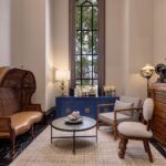 Rattan settee, blue cabinet, and vintage sewing machine