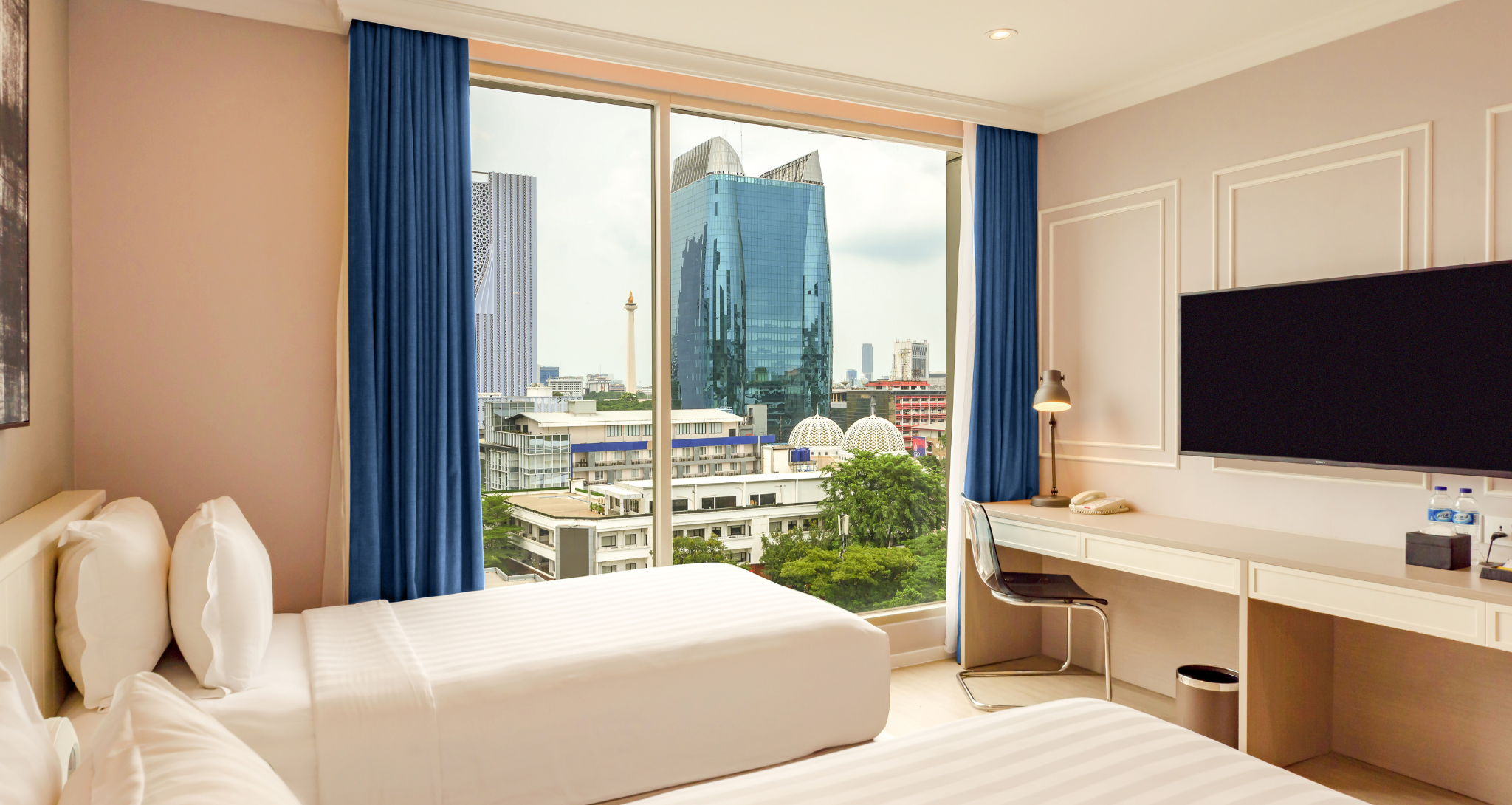 Modern hotel room with two twin beds and a city view