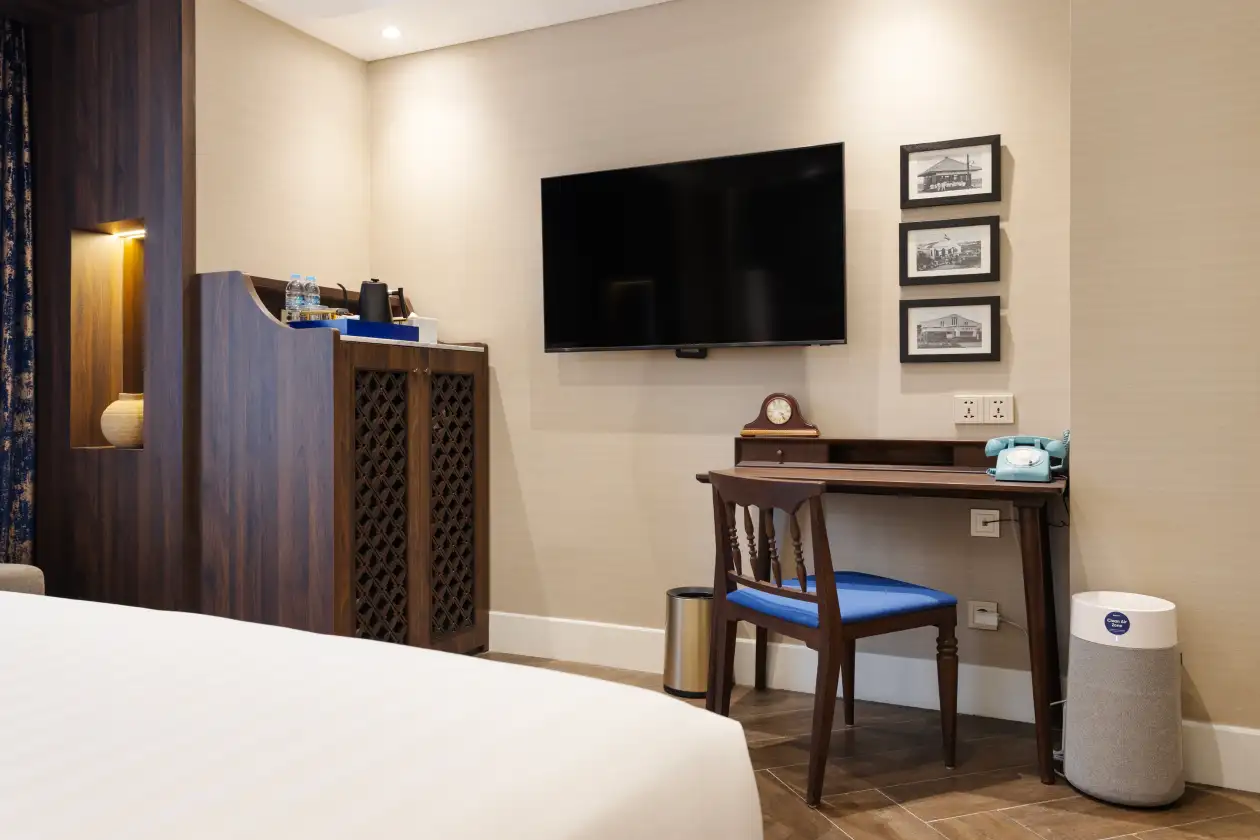 Deluxe Queen room showing TV, desk, and Blueair purifier