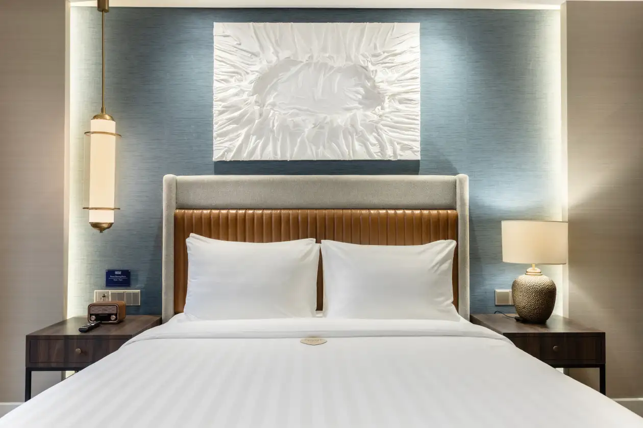 NewAir Executive Queen room, bed, blue wall, white art