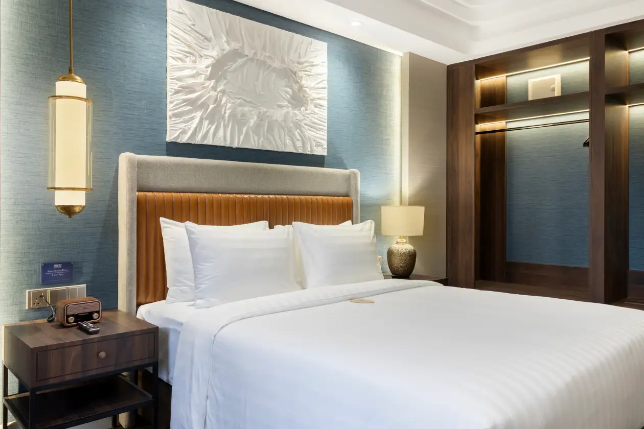 Executive Queen room interior, blue wall, white bed, dark wood