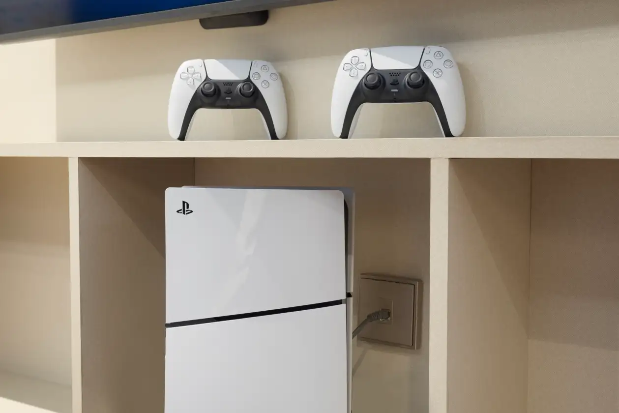 PS5 console and controllers in a family duplex room