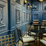 Deep blue paneled wall facility with empty frames and seating